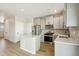 Modern kitchen features an island, stainless steel appliances, light gray cabinetry, and attractive wood-look floors at 9484 Yampa St, Commerce City, CO 80022