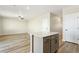 Spacious living area featuring modern light fixtures, wood-look floors, and a kitchen island at 9484 Yampa St, Commerce City, CO 80022