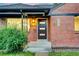 Home exterior with modern front door, brick facade, and a manicured bush adding curb appeal at 2731 W 42Nd Ave, Denver, CO 80211