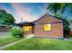Charming brick home featuring a well-manicured lawn and inviting front porch at sunset at 2731 W 42Nd Ave, Denver, CO 80211