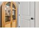 Hallway cabinet with glass doors and gold hardware beside a white paneled door with black hardware at 2731 W 42Nd Ave, Denver, CO 80211
