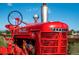 Antique red Farmall tractor highlighting rural lifestyle of this expansive and unique property at 2108 Chambers Rd, Brighton, CO 80601