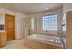 Bright bathroom featuring marble-clad bathtub, glass shower enclosure and a marble-top vanity with wood cabinets at 5284 Taft Ct, Arvada, CO 80002