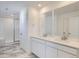 Modern bathroom with double vanity, sleek mirrors, and a glass-enclosed shower at 7213 Waterleaf Trl, Littleton, CO 80125