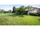 Manicured lawn with mature trees, tennis court and greenhouse in this sprawling backyard at 6211 E Orchard Dr, Greenwood Village, CO 80111