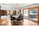 Bright dining room with wood floors, a chandelier, and sliding doors leading to an outdoor seating area near the tennis court at 6211 E Orchard Dr, Greenwood Village, CO 80111