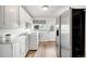 Bright laundry room with modern appliances, white cabinetry, and a convenient utility sink at 6211 E Orchard Dr, Greenwood Village, CO 80111