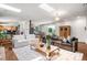 An open-concept living room featuring hardwood floors and skylights, with seamless access to the dining area at 6211 E Orchard Dr, Greenwood Village, CO 80111