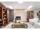 Bright living room with a stone fireplace, hardwood floors, and built-in wooden bookshelves at 6211 E Orchard Dr, Greenwood Village, CO 80111