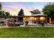 Outdoor patio with a built-in grill, dining area and seating overlooking a lush green lawn at 6211 E Orchard Dr, Greenwood Village, CO 80111