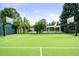 Private tennis court with basketball hoops surrounded by trees and a white pergola in the background at 6211 E Orchard Dr, Greenwood Village, CO 80111