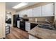 Practical kitchen with white cabinets, efficient layout, and wood floors at 8180 Washington St # 126, Denver, CO 80229