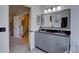 Stylish bathroom featuring a gray double vanity with granite countertop and a large framed mirror at 2888 Deer Creek Trl, Highlands Ranch, CO 80129