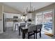 Open dining area with modern chandelier, patio access, and white kitchen in background at 2888 Deer Creek Trl, Highlands Ranch, CO 80129