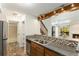 Spacious kitchen with stainless sink, wooden cabinets, and a view to the living room and fireplace at 2575 S Syracuse Way # M307, Denver, CO 80231