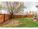 Spacious backyard featuring a large grassy area, a wooden fence, and a stone paver area at 6647 Lynx Cv, Lone Tree, CO 80124