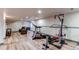 Finished basement with exercise equipment and comfortable seating area on beautiful floors at 6647 Lynx Cv, Lone Tree, CO 80124