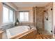 Bright bathroom featuring a modern soaking tub and separate glass shower at 6647 Lynx Cv, Lone Tree, CO 80124