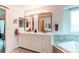 Bright bathroom with double vanity, modern mirrors, and a soaking tub, creating a spa-like atmosphere at 6647 Lynx Cv, Lone Tree, CO 80124
