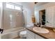 Bathroom with tiled shower-tub, vanity with copper colored countertop and neutral finishes at 6647 Lynx Cv, Lone Tree, CO 80124