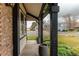 Inviting front porch with black columns, brick accents, and views of the landscaped front yard at 6647 Lynx Cv, Lone Tree, CO 80124