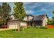 Charming two-story home featuring a manicured lawn, solar panels, and beautiful landscaping at 6647 Lynx Cv, Lone Tree, CO 80124