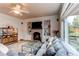 Comfortable living room with brick fireplace, built-in shelves, large window, and a cozy gray sectional at 6647 Lynx Cv, Lone Tree, CO 80124