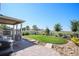 Beautiful backyard with a covered patio, stone patio, manicured lawn, and lush landscaping at 6193 Saddle Bow Ave, Parker, CO 80134