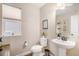 Powder room featuring a pedestal sink, toilet, a window and light neutral paint at 6193 Saddle Bow Ave, Parker, CO 80134