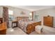 Bedroom features a floral-patterned bed set, wood furniture and windows providing natural light to the carpeted space at 6193 Saddle Bow Ave, Parker, CO 80134