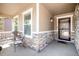 Inviting front porch with stone accents, seating, and a stylish front door with large windows at 6193 Saddle Bow Ave, Parker, CO 80134