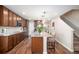 A kitchen with dark wood cabinets, hardwood floors and a granite countertop island with seating and modern stainless appliances at 6193 Saddle Bow Ave, Parker, CO 80134
