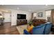 Inviting living room features dark wood floors, comfortable seating, and a large television at 6193 Saddle Bow Ave, Parker, CO 80134