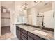 Modern bathroom with double vanity sinks, granite counters, and glass-enclosed shower at 12441 W Virginia Ave, Lakewood, CO 80228