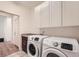 Bright laundry room featuring modern Samsung washer and dryer with ample storage cabinets at 12441 W Virginia Ave, Lakewood, CO 80228