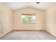 Neutral bedroom with vaulted ceilings, window, and carpeted floors at 8879 Apache Plume Dr, Parker, CO 80134