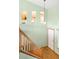 Foyer with hardwood floors, staircase with wooden railing, high ceilings, and glimpses of the kitchen at 8879 Apache Plume Dr, Parker, CO 80134