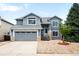 Charming two-story home boasts a well-manicured lawn, inviting entrance, and attached two-car garage at 8879 Apache Plume Dr, Parker, CO 80134