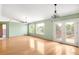 Bright living room featuring hardwood floors, large windows, deck access, and neutral paint at 8879 Apache Plume Dr, Parker, CO 80134