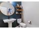 Modern powder room featuring stylish pedestal sink, unique wall decor, and contemporary fixtures at 23469 E Briarwood Pl, Aurora, CO 80016