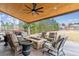 Covered outdoor living space with a stone fireplace, comfortable seating and a ceiling fan at 23469 E Briarwood Pl, Aurora, CO 80016