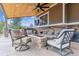 Covered outdoor living space with a stone fireplace and comfortable seating at 23469 E Briarwood Pl, Aurora, CO 80016