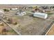 The home and large outbuilding sit on a big lot with a white fence and trees at 16665 Kenuil St, Brighton, CO 80603