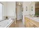 Bathroom featuring tile floors, a tub, a shower, and a sink with wooden cabinets at 16665 Kenuil St, Brighton, CO 80603