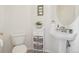 Half bathroom featuring a toilet, pedestal sink, mirror, and decorative storage at 16665 Kenuil St, Brighton, CO 80603