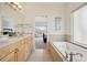 Bright bathroom featuring a bathtub, tile floor, double sinks, and a jacuzzi at 16665 Kenuil St, Brighton, CO 80603