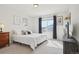 Bright bedroom featuring a cozy bed, framed art, and a window letting in plenty of natural light at 16665 Kenuil St, Brighton, CO 80603