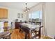 Charming dining area featuring a wooden table, bench seating, and large windows with neighborhood views at 16665 Kenuil St, Brighton, CO 80603