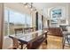 Dining room with large windows, wood table with bench seating, and an open view to the living room at 16665 Kenuil St, Brighton, CO 80603
