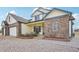 Inviting front exterior with charming details, a brick accent, manicured garden, and a spacious three-car garage at 16665 Kenuil St, Brighton, CO 80603